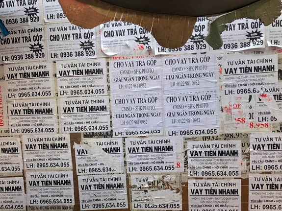Tờ rơi tư vấn cho vay dán trên tường ở chợ Phạm Văn Hai, quận Tân Bình (TP Hồ Chí Minh).